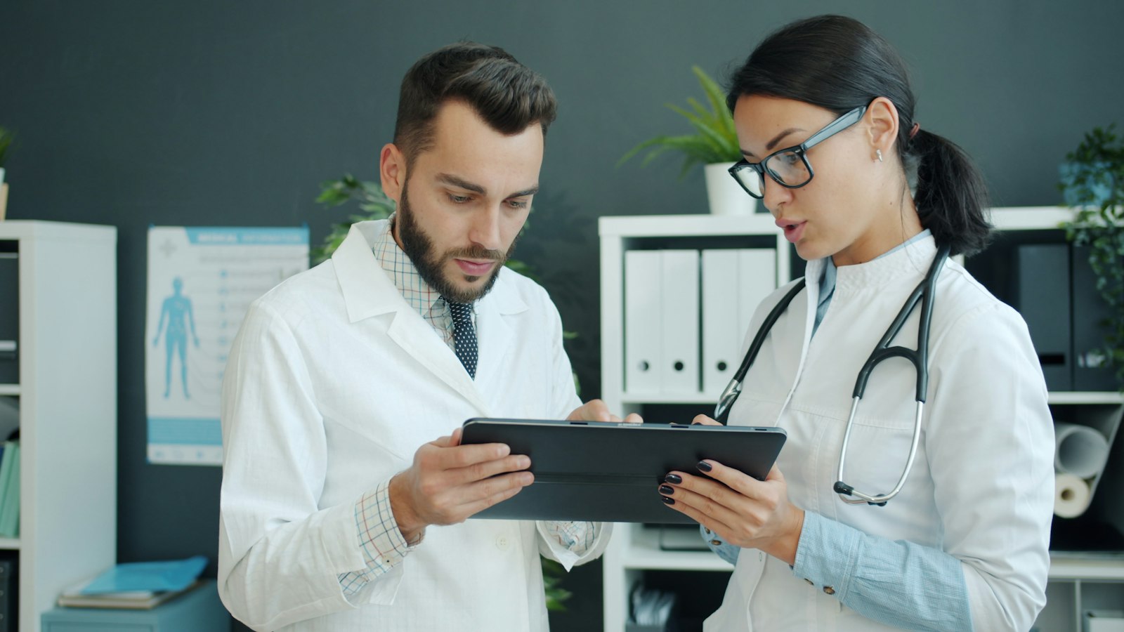 Dos médicos revisan información clínica en una tableta